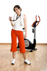 Wall Mural - Beautiful female gym instructor with a exercise bike on the background