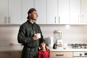 Wall Mural - Military man in olive uniform and cap with his little son after long parting at home