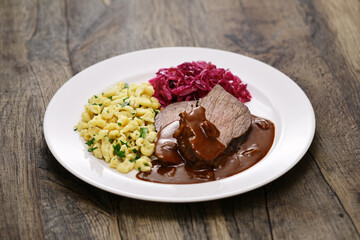 Wall Mural - Sauerbraten (a German national dish, marinated braised beef) with Rotkohl (red cabbage), Spaetzle(small egg pasta)