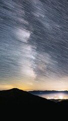 Wall Mural - vertical startrails of milky way galaxy star trails in starry night sky astronomy time lapse over co