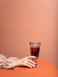 © shyrokova - Unrecognisable person in luxury beige silk shirt with well cared hands and manicured nails holding glass of wine. Concept of Wine shop, wine tasting, bar, wine list.