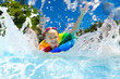 © famveldman - Child in swimming pool on toy ring. Kids swim.