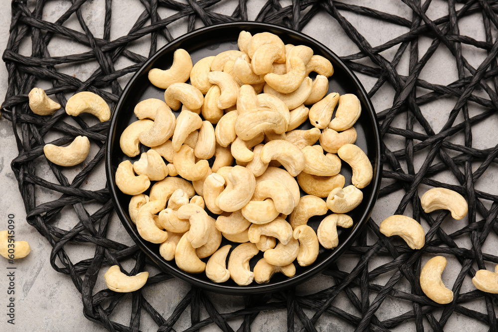 Plate with tasty cashew nuts on grunge background