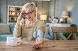 © Miljan Živković - Senior caucasian woman check blood pressure measure device on hand