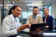 © Drazen - Black insurance agent and her clients using digital tablet during meeting.