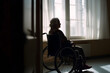 Lonely senior citizen woman in wheelchair in a nursing home. Generative AI.