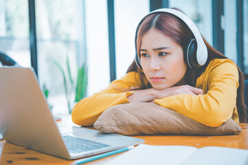 Wall Mural - Female students are bored and sleepy during online classes while sitting online for long hours.