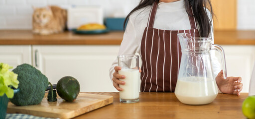 Portrait of enjoy happy little asian child girl smiling having protein breakfast drinking and hold glasses of fresh milk,healthy nutrition,calcium and vitamin,dairy product,strong, growth