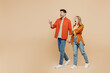 Full body young couple two friends family man woman wear casual clothes together point index finger aside indicate on workspace area copy space mock up isolated on pastel plain beige color background.
