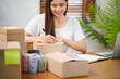 © Charlie's - Business From Home Asian woman preparing package delivery box Shipping for shopping online. young start up small business owner at home online order