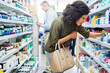 © Tamani C/peopleimages.com - Pharmacy, shopping and woman with medicine check and product in a retail store. Pharmaceutical, drugs and pills with a African female person looking at box for ingredients and information in shop