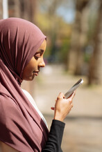 Young Woman In Hijab Using Phone