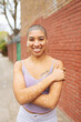 © Connect Images - Portrait of hipster young woman standing in front of brick wall