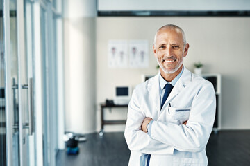 Wall Mural - Mature doctor, worker and portrait with arms crossed in hospital feeling proud from medical work. Healthcare, wellness and physician employee smile with happiness from health support and mockup