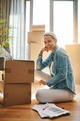 Wall Mural - Woman, boxes and portrait with document on the floor with a smile at a new home for investment. Property, box and paperwork with happiness for investing in real estate for finance and retirement.