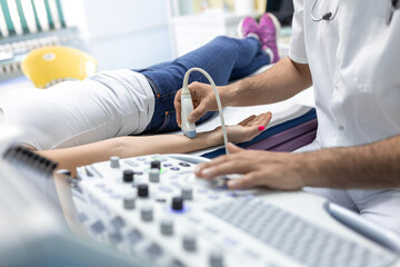 Wall Mural - Cropped view of the male doctor holding special device while making ultrasound therapy for woman. Ultrasound of the veins of the upper xtremities concept