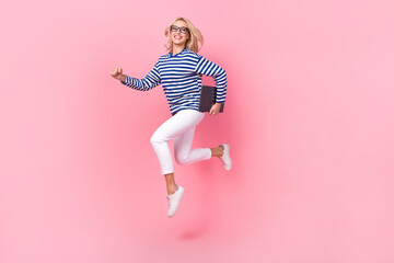 full length photo of cute purposeful lady wear striped shirt spectacles jumping holding gadget isola