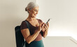 © JLCo Ana Suanes - Senior woman using a fitness app for her yoga routine at home