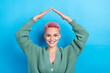 © deagreez - Photo of optimistic charming girl show dyed pink hairdo showing hands roof safety feel comfortable home isolated on blue color background