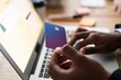 © Studio Marmellata - Unrecognizable male using modern laptop while entering credit card credentials into computer during online shopping