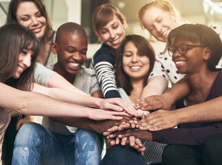 Goal, motivation and friends with their hands in a huddle together for education, support or success. Teamwork, smile and trust with a happy group of students bonding at college or university