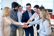 Group of businesspeople stacking hands in a tight circle, to strategize, motivate or celebrate their unity in the office.