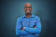 Business, black man and portrait with arms crossed in a studio feeling proud from auditor work. Blue background, smile and African employee with success and leadership vision with glasses and idea