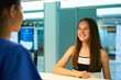 © Tamani C/peopleimages.com - Help, reception and nurse with patient in hospital for advice, medical and information. Medicine, happy and healthcare with teenage girl at desk in clinic for nursing, waiting room and service