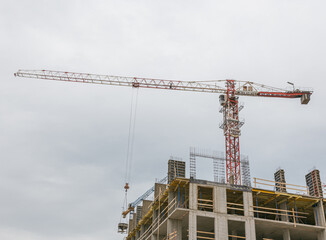 Construction site. Construction cranes and a building under construction against a blue sky background. 