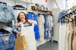 © Austockphoto - Happy young lady with down syndrome shopping in dress and clothing store boutique