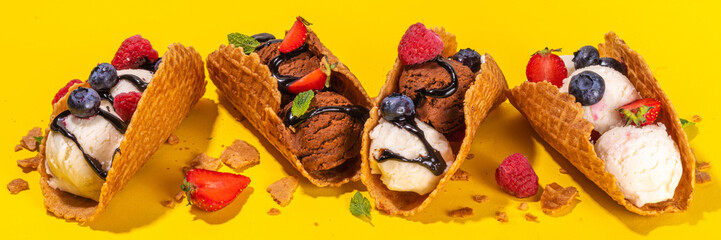 Various sweet taco ice creams. Waffle taco shells with chocolate and vanilla flavour ice cream with different fruits, berry, toppings