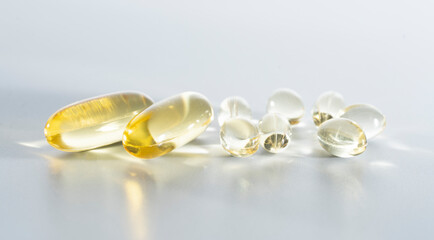 Wall Mural - Vitamin D yellow supplement gel capsules, Fish Oil Omega 3 on white background, macro shot 