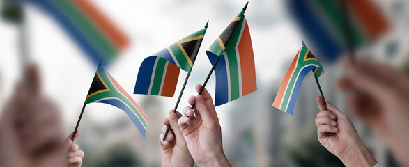 Wall Mural - A group of people holding small flags of the South Africa in their hands