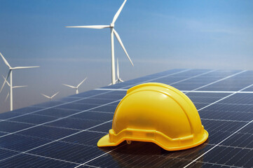 Wall Mural - yellow safety helmet on solar panel with turbine background. eco environment concept