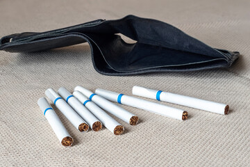 An empty wallet with cigarettes. The concept of unjustified spending on cigarettes. Smoking leads to poverty