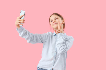 Poster - Little girl with mobile phone video chatting on pink background