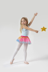 Wall Mural - Studio portrait of beautiful little princess holding star shaped magic wand