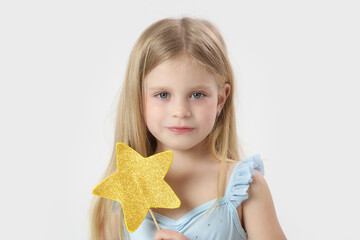 Wall Mural - Studio portrait of beautiful little princess holding star shaped magic wand	