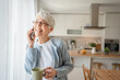 © Miljan Živković - One senior woman with short gray hair use smartphone at home portrait