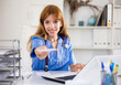 © JackF - Positive woman physician sitting at table in her office and giving recipe.