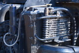 Fototapeta  - Intercooler in front of the radiator. Closeup of old excavator turbo intercooler panel in front of outdoor radiator for cooling heavy equipment with selective focus