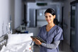 © Wavebreak Media - Portrait of happy biracial female doctor holding tablet and smiling in hospital corridor