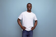 handsome young african man in white t-shirt on blue background with copy space