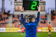 Sideline referee shows 2 minutes added time during the football match.