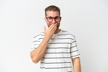 Wall Mural - Young handsome caucasian man isolated on white background happy and smiling covering mouth with hand