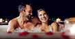 © MVD Merwe/peopleimages.com - Spa, love and couple in a jacuzzi happy, smile and relax one date night at a wellness resort. Zen, hot tub and man with woman laughing, peace and enjoying a romantic vacation, holiday or anniversary