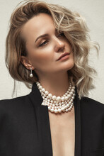 Beautiful Young Blondy Woman With A Lot Of Jewelry Around Her Neck. Lots Of Pearl Necklaces And Bracelets.