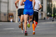 © sports photos - rear view three runners athletes running marathon in city, group male jogger summer sports race