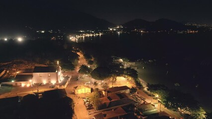 Wall Mural - Aerial view of the coastal town of Santo Antonio de Lisboa in Brazil during night time. Footage has high level of noise