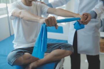 Doctor or physical therapist examines back pain and spinal area to give advice within the rehabilitation center.